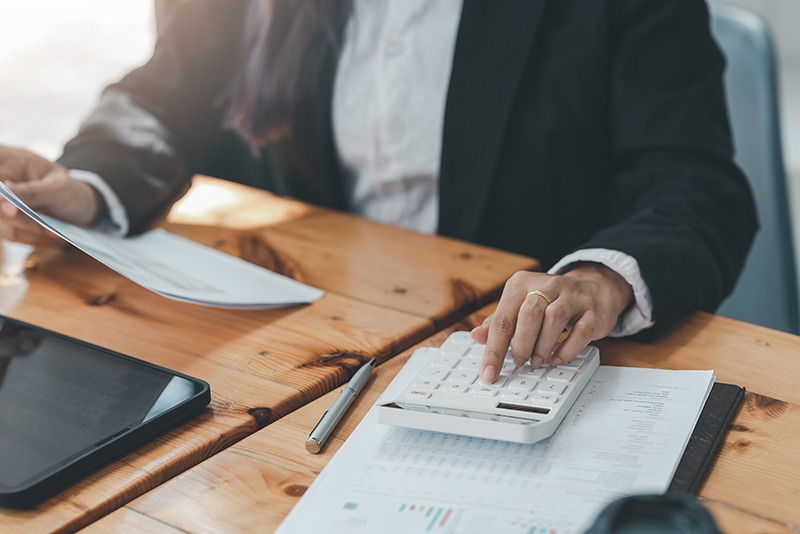 Close up of a businesswoman with hand using a calculator to calc accountant using a calculator
